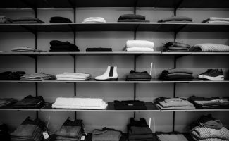 grayscale-photography-of-assorted-apparels-on-shelf-rack-1884581
